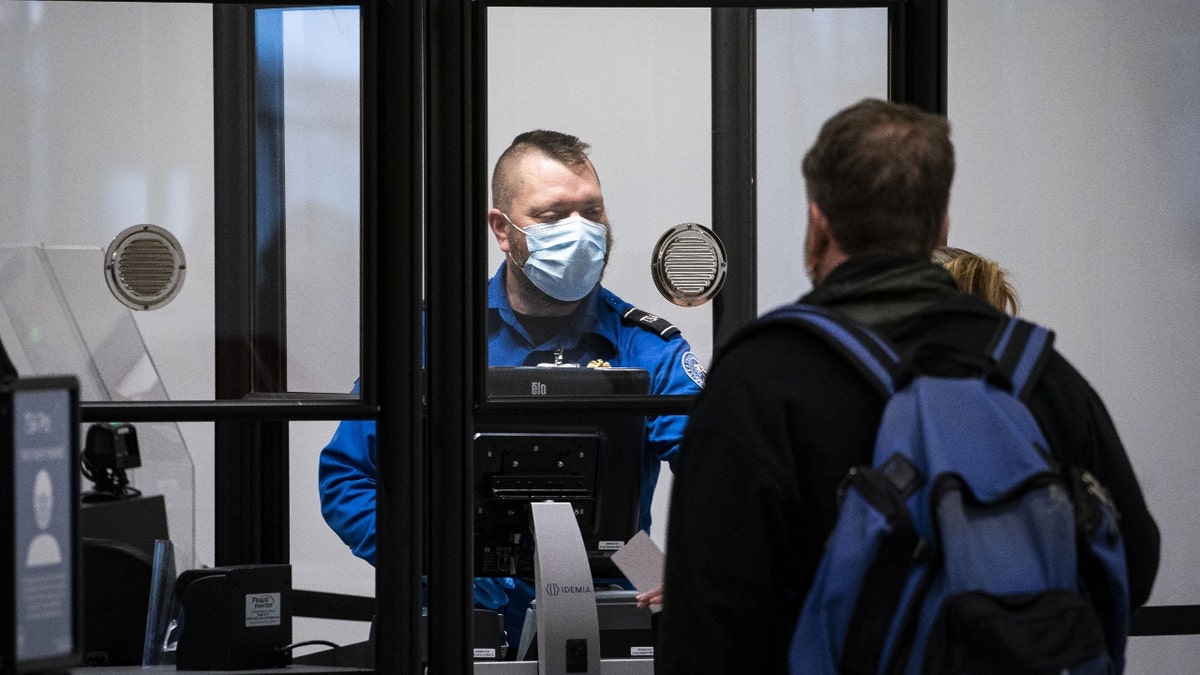 A Transportation Security Administration (TSA) agent screens a traveler at a checkpoint in terminal 2 at Raleigh-Durham International Airport (RDU) in Morrisville, North Carolina, U.S., on Thursday, Jan. 20, 2022. For the third time in less than two months, the U.S. aviation system on Tuesday faced the threat of widespread flight disruptions over potential 5G interference, only to get a temporary reprieve. Photographer: Al Drago/Bloomberg