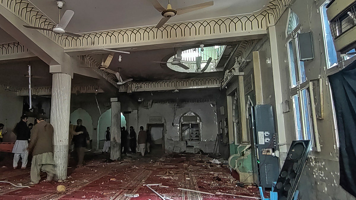 Security personnel inspect a mosque after a bomb blast in Peshawar on March 4, 2022.