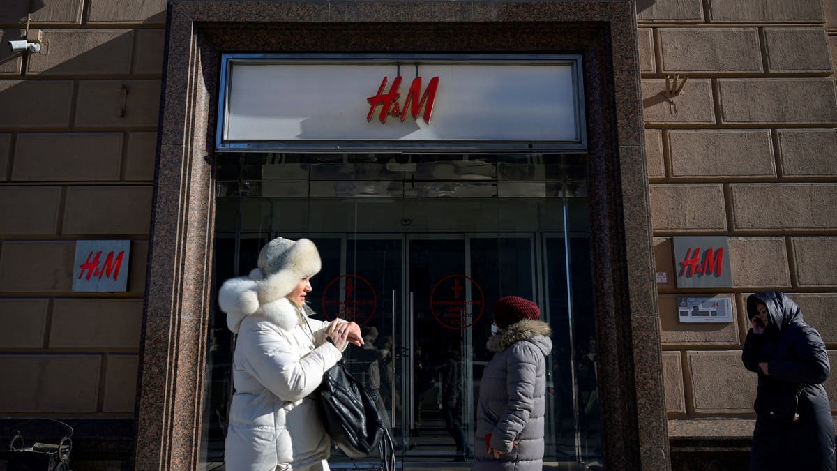 People walk past a closed H&amp;M store in Moscow on March 10, 2022, after Swedish clothing giant Hennes and Mauritz halted all sales in its Russian stores over the war in Ukraine.