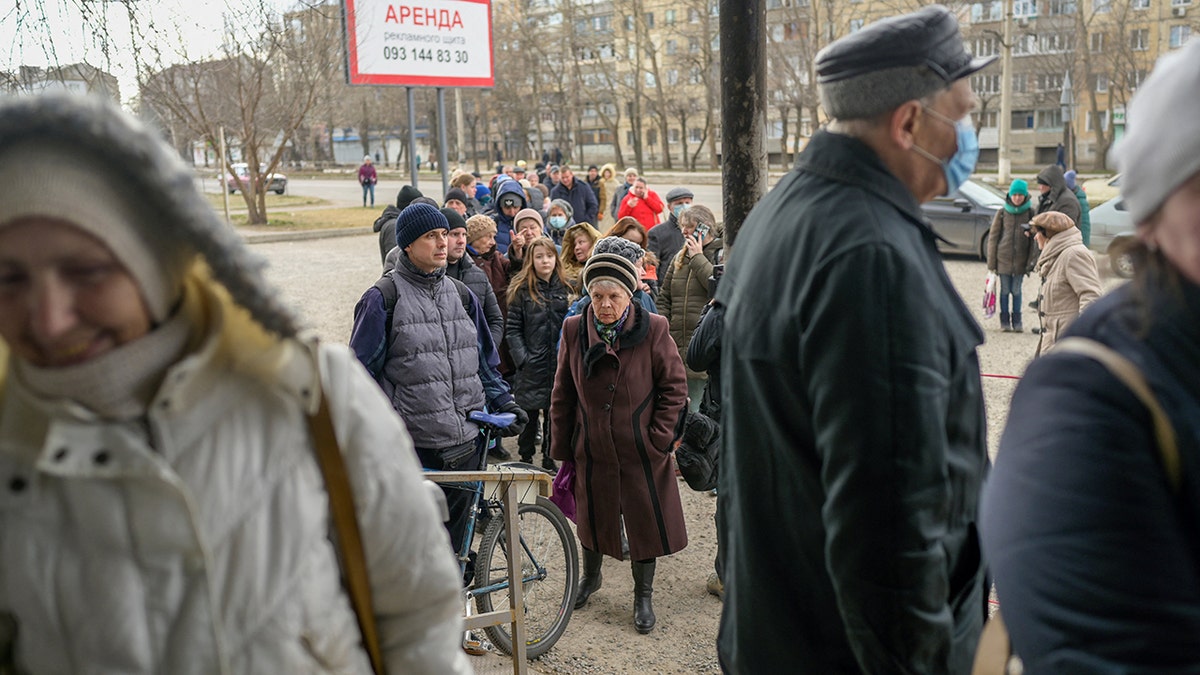 People line up for a food distribution in front of a supermarket in Mykolaiv, on March 14, 2022, on the third week of Russian invasion of Ukraine. 