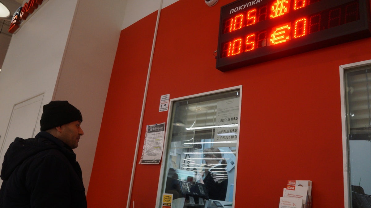 MOSCOW, RUSSIA - MARCH,15 (RUSSIA OUT): A man looks to the screen displaying the rates of U.S. Dollar and EURO to Russian Ruble at the bank at a shopping mall, March 15, 2022, in Moscow, Russia. McDonald's closed all its restaurants, KFC suspended any investment in Russia as a result of the U.S. and EU economic sanctions.