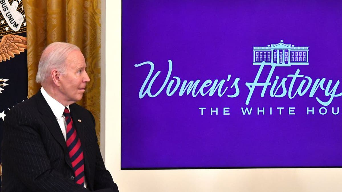 President Joe Biden listens as first lady Jill Biden speaks during the Equal Pay Day event to celebrate Womens History Month in the East Room of the White House in Washington, D.C., March 15, 2022.