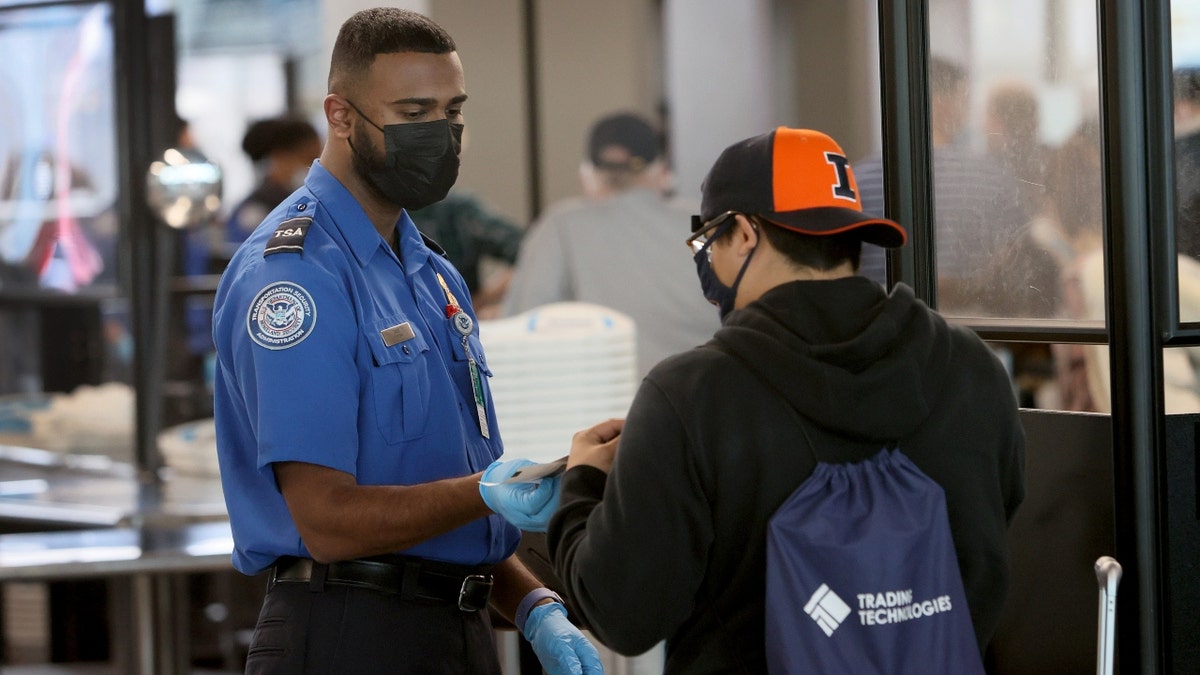 Transportation Security Administration (TSA) workers screen passengers at O'Hare International Airport on November 08, 2021 in Chicago, Illinois. Monday is the deadline for federal workers to report whether they have been vaccinated against the COVID-19 coronavirus. Recent data indicate that only about 60 percent of TSA workers have reported being vaccinated. (Photo by Scott Olson/Getty Images)