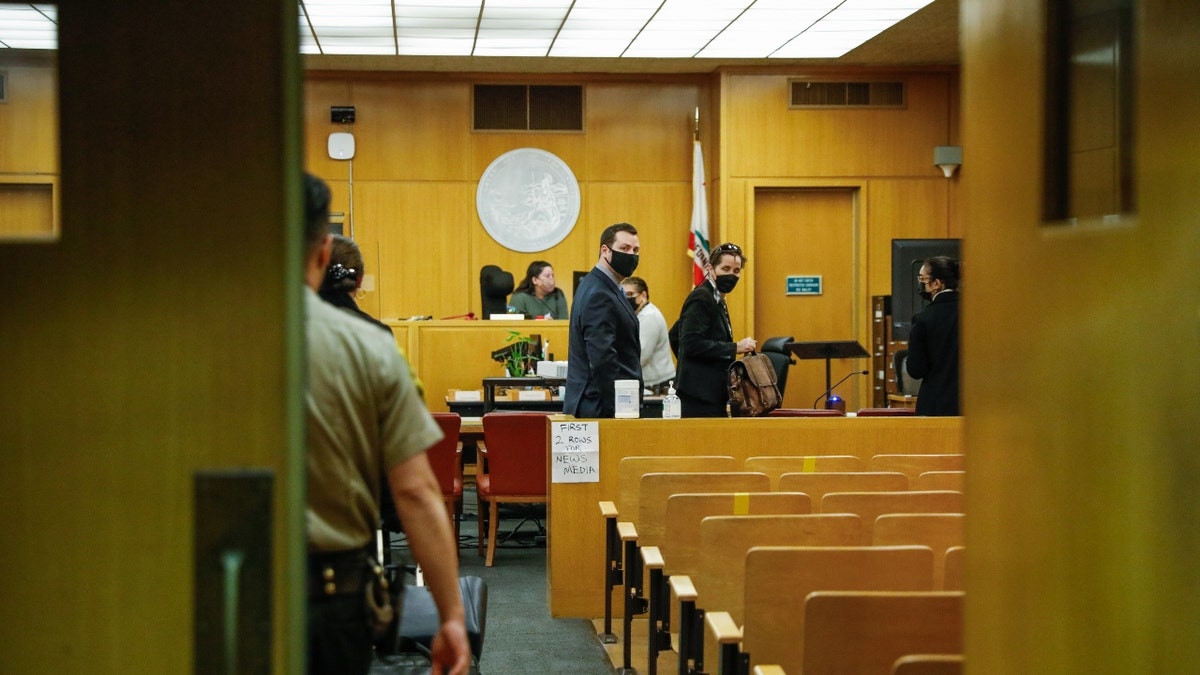 San Francisco Police officer Terrance Stangel (center) and lawyer Nicole Pifari (right) walk into the courtroom at the Hall of Justice on Tuesday, Feb. 8, 2022 in San Francisco, California. (Gabrielle Lurie/San Francisco Chronicle via Getty Images)
