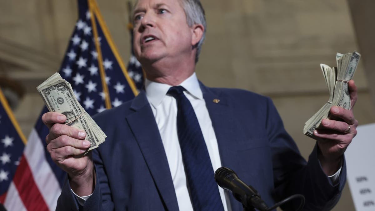 Kansas Sen. Roger Marshall holds stacks of money as he speaks during a press conference on inflation, at the Russell Senate Office Building on Feb. 16, 2022 in Washington, D.C.