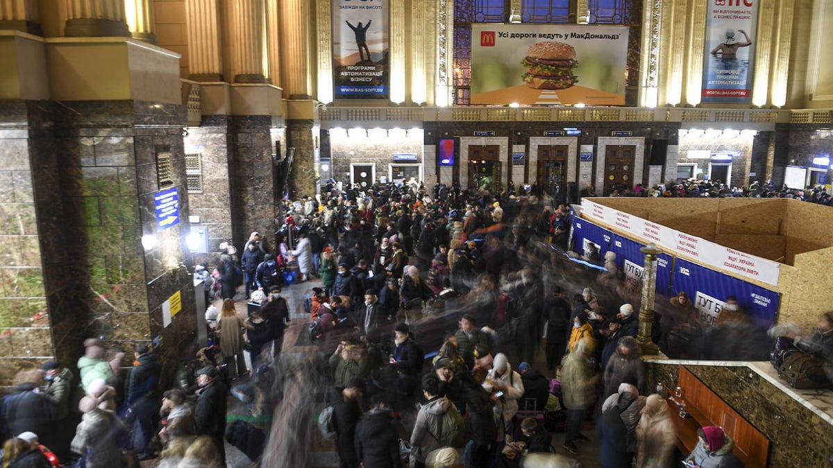 People wait at a train station to board trains in Kyiv