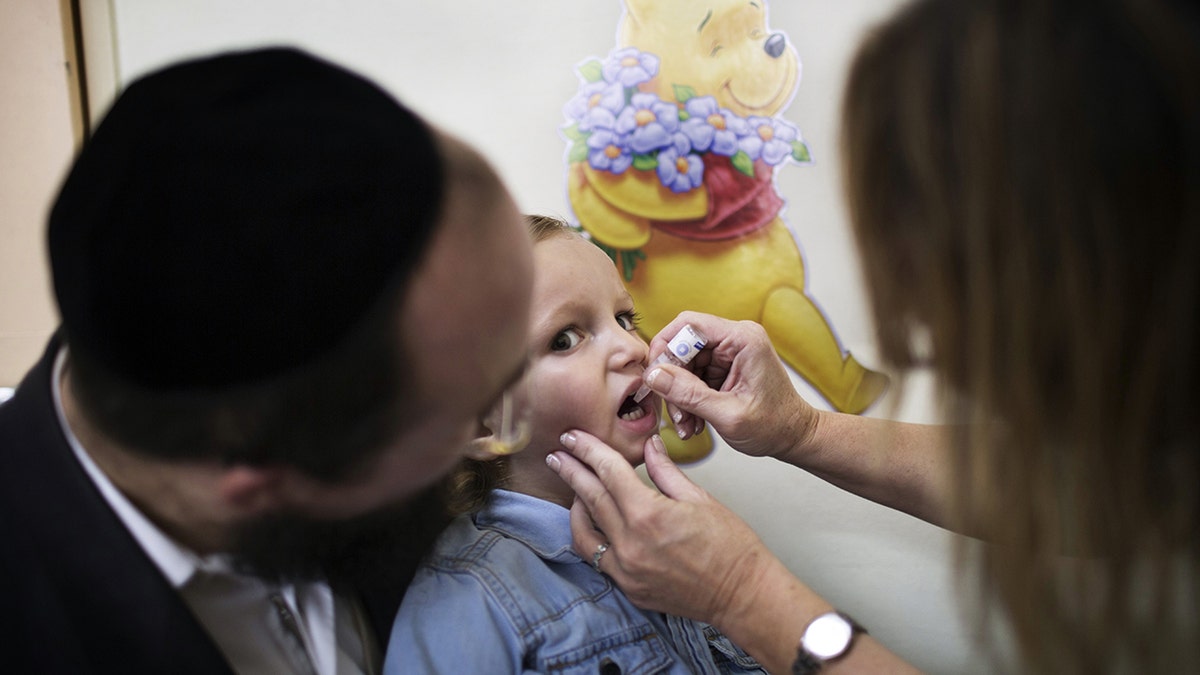 An Israeli child receives a vaccination against Polio at a clinic in Jerusalem on August 18, 2013. (AFP PHOTO/MENAHEM KAHANA)