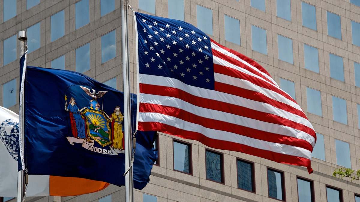 A set of three flags, the United States, New York State and the City of New York flags seen in Lower Manhattan, New York City.