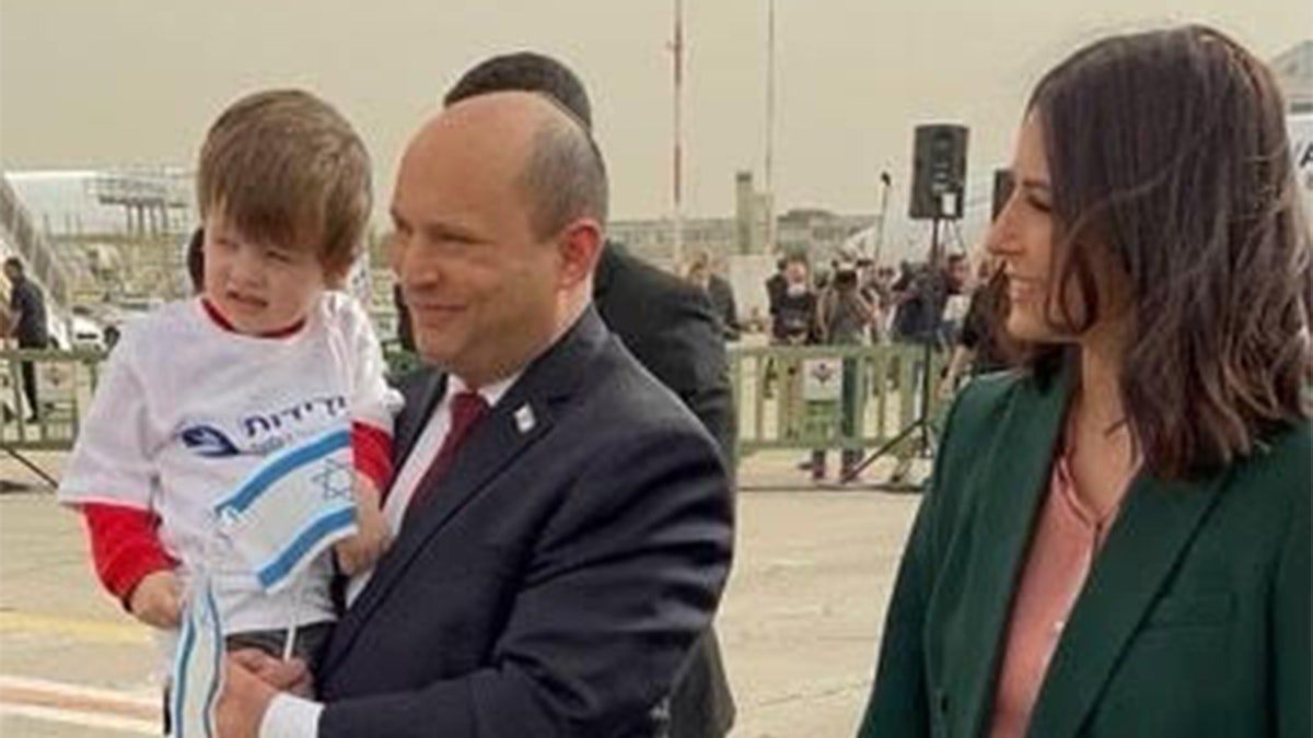 Israel’s Prime Minister, Naftali Bennett, holds a child who made it safely out of Ukraine