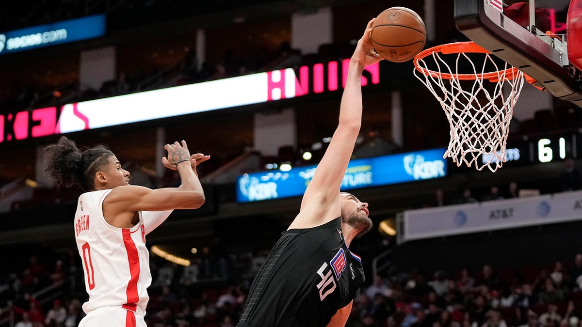 Los Angeles Clippers center Ivica Zubac, right, dunks as Houston Rockets guard Jalen Green defends during the second half of an NBA basketball game, Sunday, Feb. 27, 2022, in Houston.