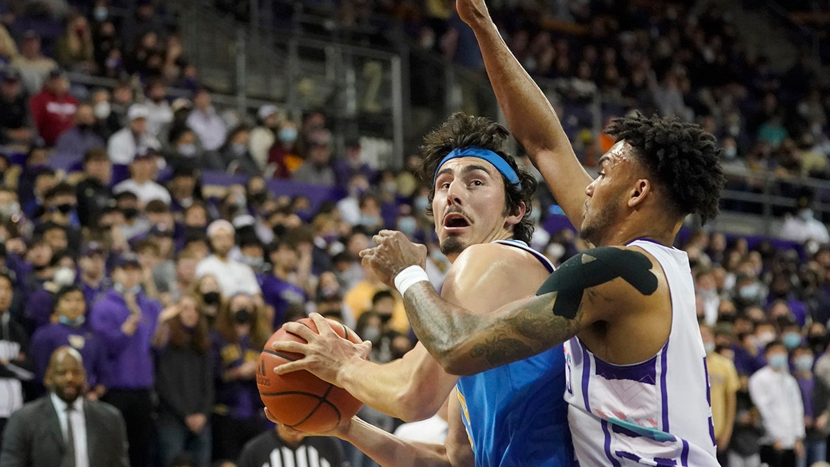 UCLA guard Jaime Jaquez Jr., left, is guarded by Washington guard Jamal Bey, right, during the first half of an NCAA college basketball game, Monday, Feb. 28, 2022, in Seattle. 