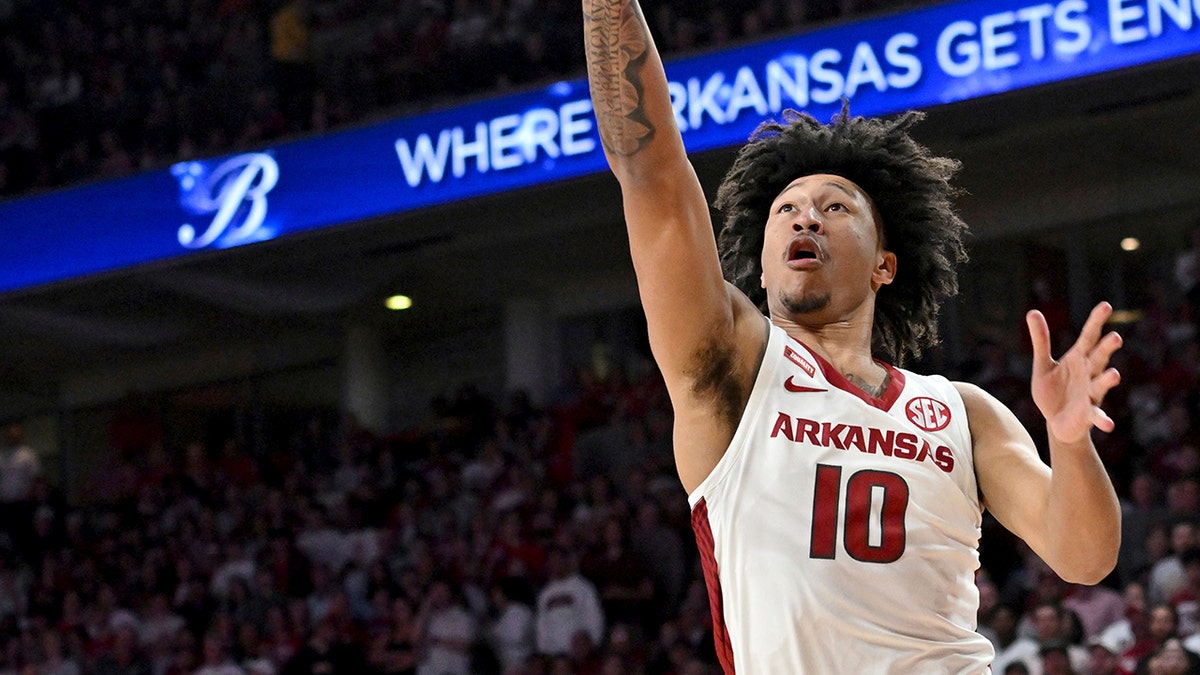 Arkansas forward Jaylin Williams (10) drives past LSU guard Brandon Murray (0) to score during the first half of an NCAA college basketball game Wednesday, March 2, 2022, in Fayetteville, Ark.