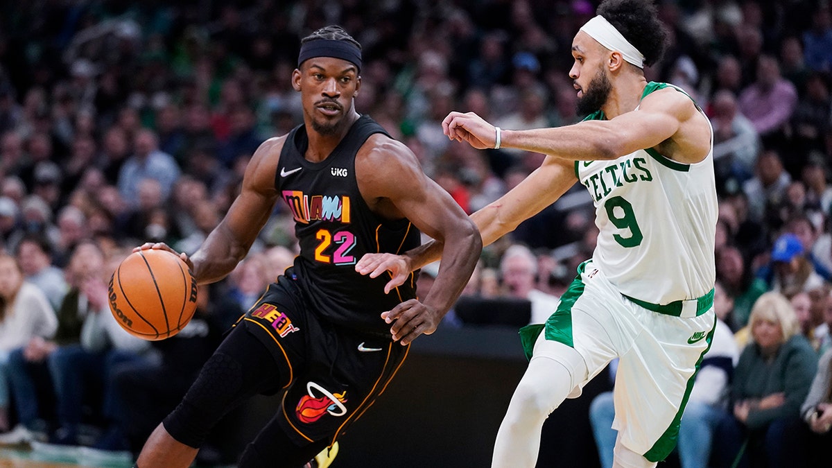 Miami Heat forward Jimmy Butler (22) drives to the basket against Boston Celtics guard Derrick White (9) during the second half of an NBA basketball game Wednesday, March 30, 2022, in Boston.