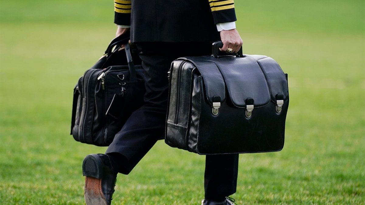 A military aide carries the "President's emergency satchel," also known as "the football," which contains nuclear launch codes, before boarding Marine One behind President Biden on the South Lawn of the White House, Wednesday, March 23, 2022, in Washington. (AP Photo/Patrick Semansky)