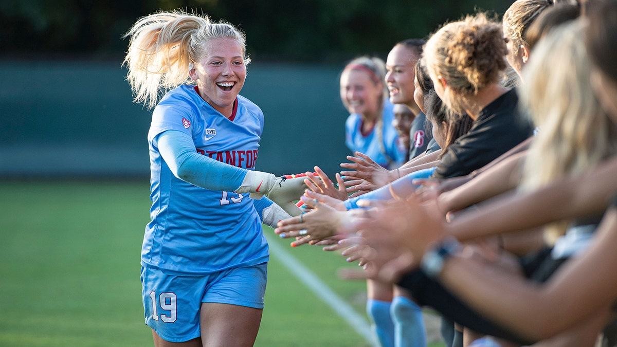 Katie Meyer high fives teammates