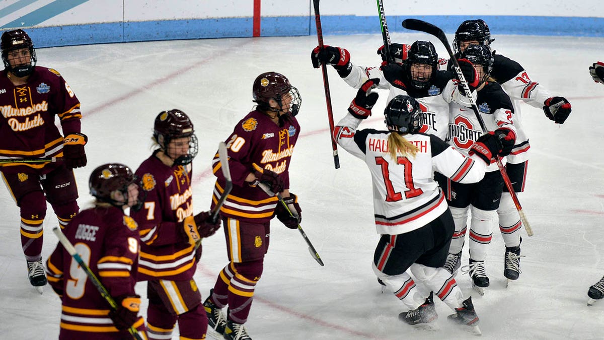 Ohio State's Kenzie Hauswirth (11) is congratulated by teammates after scoring the winning goal during the third period of an NCAA college Frozen Four Hockey championship game against Minnesota-Duluth, Sunday, March 20, 2022, in State College, Pa.