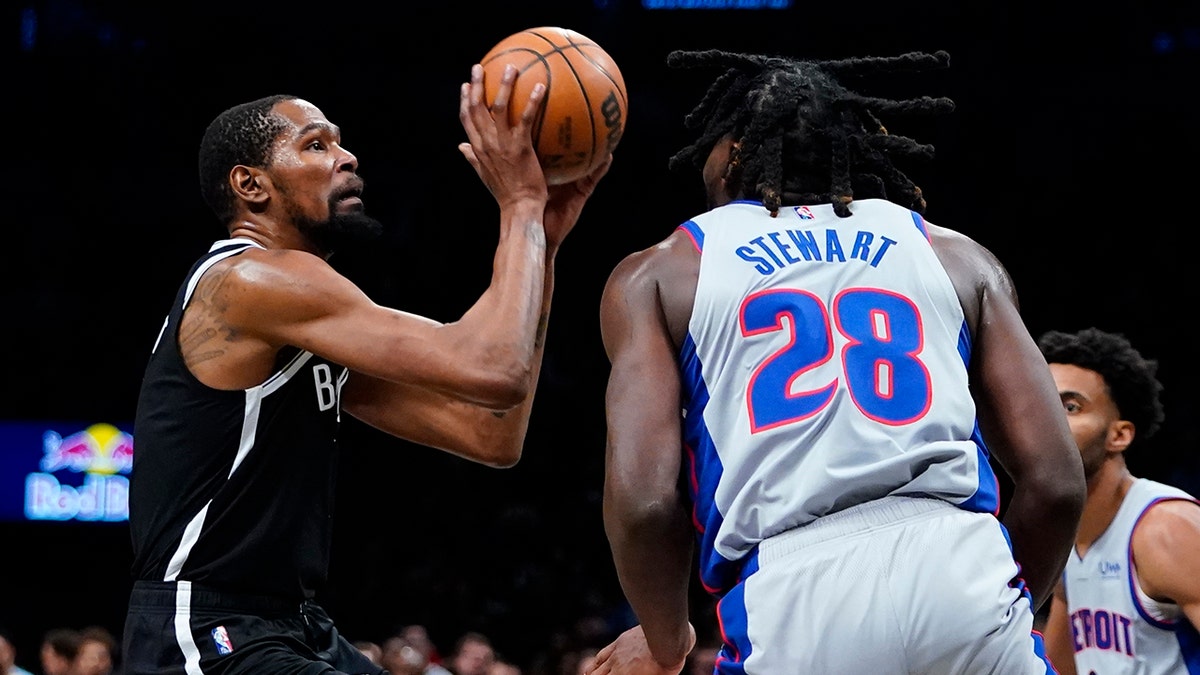 Brooklyn Nets' Kevin Durant, left, shoots over Detroit Pistons' Isaiah Stewart during the second half of an NBA basketball game Tuesday, March 29, 2022 in New York. The Nets won 130-123.