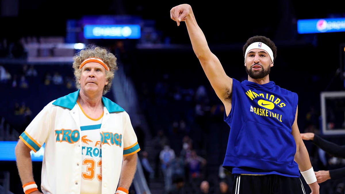 Actor Will Ferrell, left, watches as Golden State Warriors guard Klay Thompson warms up for the team's NBA basketball game against the Los Angeles Clippers in San Francisco, Tuesday, March 8, 2022. 