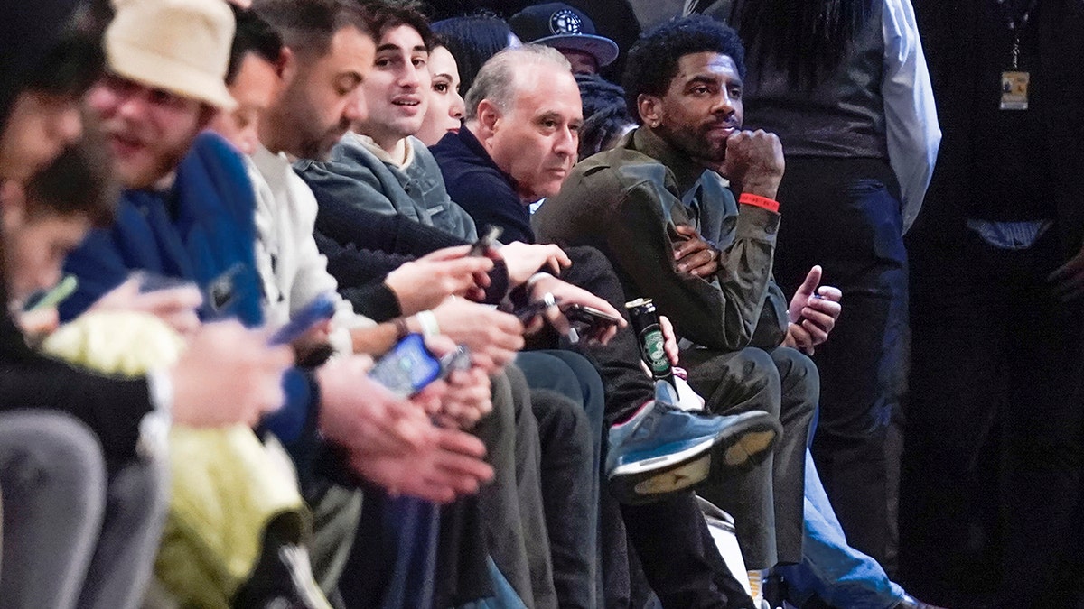 Brooklyn Nets' Kyrie Irving, far right, watches the game between the Brooklyn Nets and the New York Knicks at the Barclays Center, Sunday, March 13, 2022, in New York.