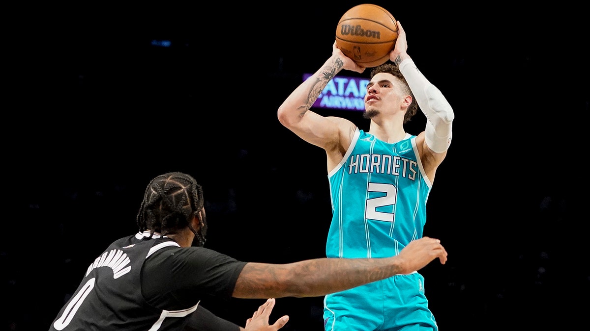 Charlotte Hornets guard LaMelo Ball (2) shoots over Brooklyn Nets center Andre Drummond (0) in the first half of an NBA basketball game, Sunday, March 27, 2022, in New York.