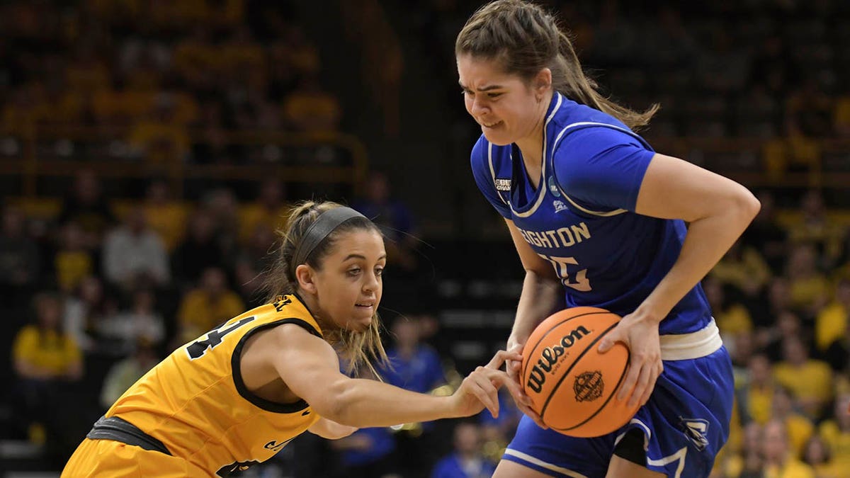 Creighton guard Lauren Jensen (15) drives to the basket as Iowa guard Gabbie Marshall (24) tries to grab the ball during the first half of a second-round game in the NCAA women's college basketball tournament, Sunday, March 20, 2022, in Iowa City, Iowa.