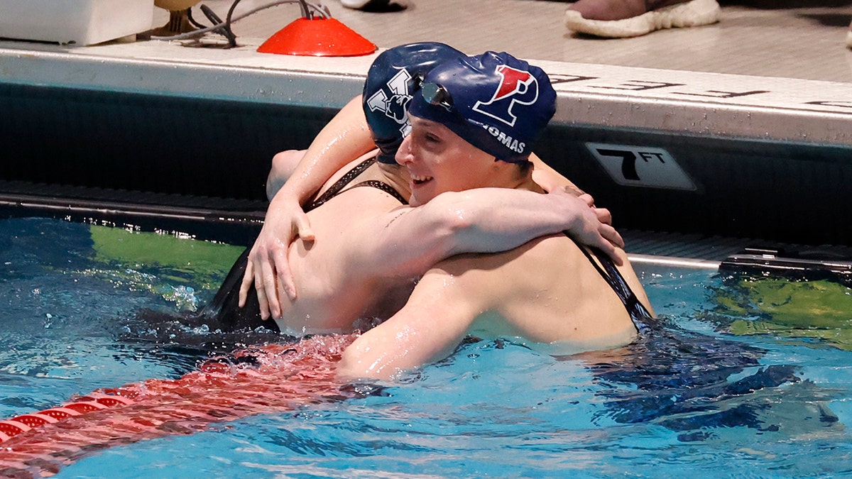 Pennsylvania's Lia Thomas, right, gets a hug from Yale's Iszak Henig after Thomas won the 100-yard freestyle final and Henig finished second at the Ivy League women's swimming and diving championships at Harvard, Saturday, Feb. 19, 2022, in Cambridge, Massachusetts.