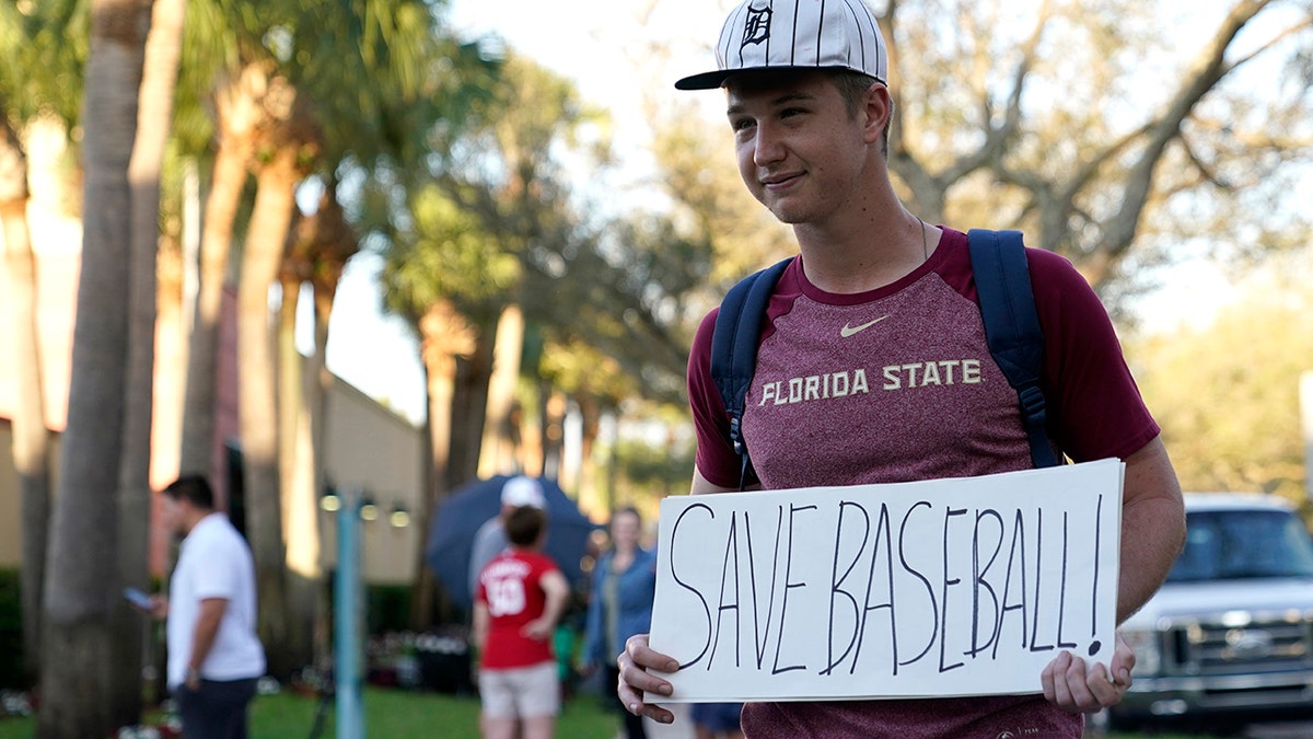 Baseball fan Noah McMurrain of Boynton Beach, Florida, stands outside Roger Dean Stadium in Jupiiter, Florida, on Feb. 28, 2022, as Major League Baseball negotiations continue in an attempt to salvage a March 31 start to the regular season.