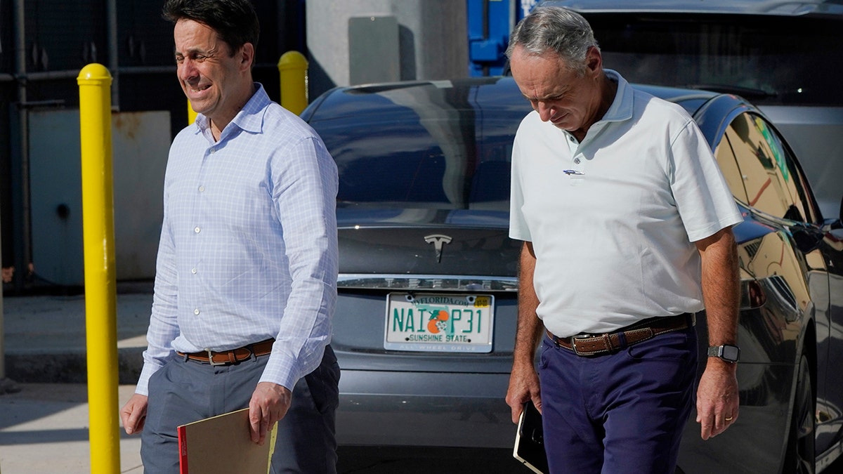 Major League Baseball Deputy Commissioner Dan Halem, left, and Commissioner Rob Manfred, right, walk after negotiations with the players association in an attempt to reach an agreement to salvage March 31 openers and a 162-game season, Monday, Feb. 28, 2022, at Roger Dean Stadium in Jupiter, Fla.