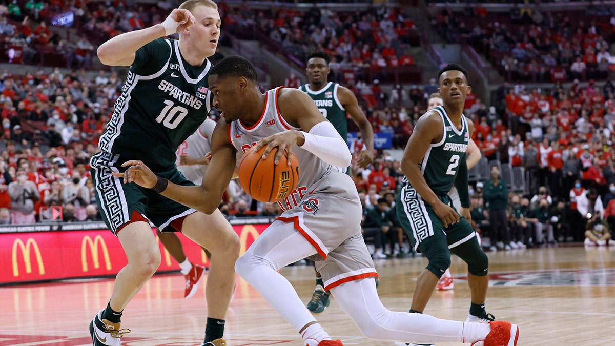 Ohio State's Malaki Branham, front, drives the baseline against Michigan State's Joey Hauser during the second half of an NCAA college basketball game Thursday, March 3, 2022, in Columbus, Ohio.