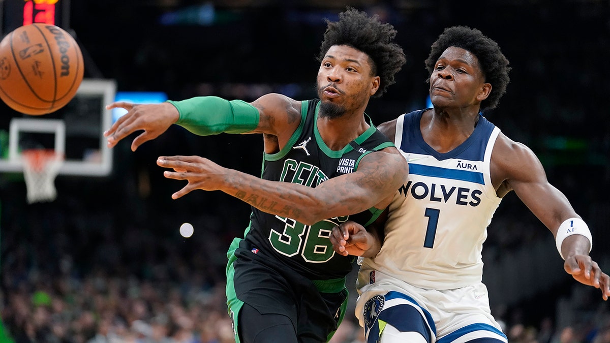 Boston Celtics guard Marcus Smart (36) passes the ball as Minnesota Timberwolves forward Anthony Edwards (1) tries to defend in the first half of an NBA basketball game, Sunday, March 27, 2022, in Boston.