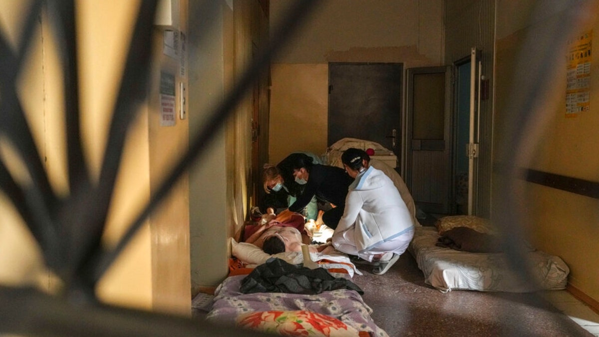 Medical workers treat a man wounded by shelling in a hospital in Mariupol, Ukraine, Friday, March 4, 2022. 
