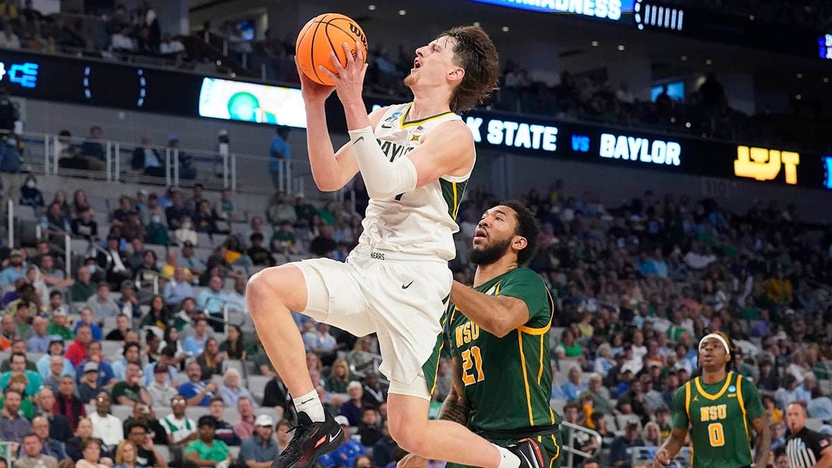 Baylor guard Matthew Mayer, left, drives past Norfolk State forward Dana Tate (21) during the second half of a college basketball game in the first round of the NCAA tournament in Fort Worth, Texas, Thursday, March 17, 2022.