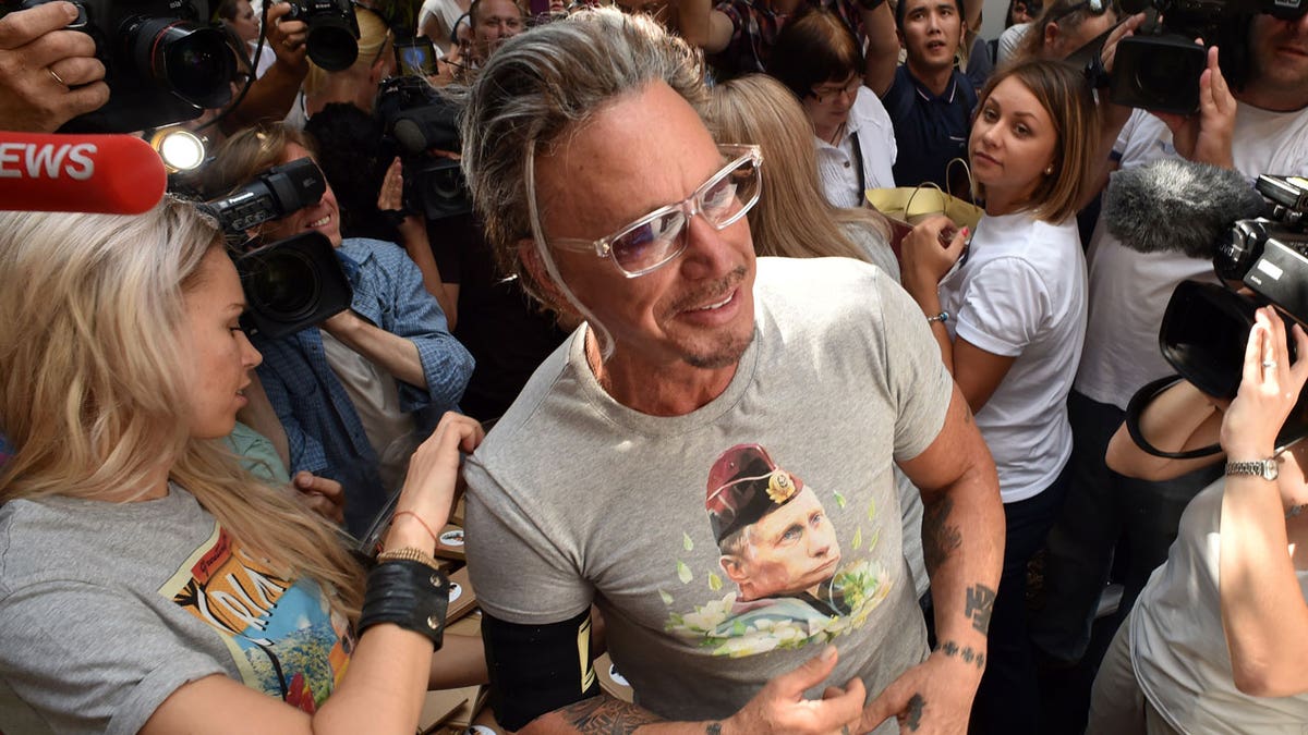 Mickey Rourke recalled meeting Vladimir Putin four years ago. He is pictured here in 2014 wearing a T-shirt with the Russian president's face on it.?
