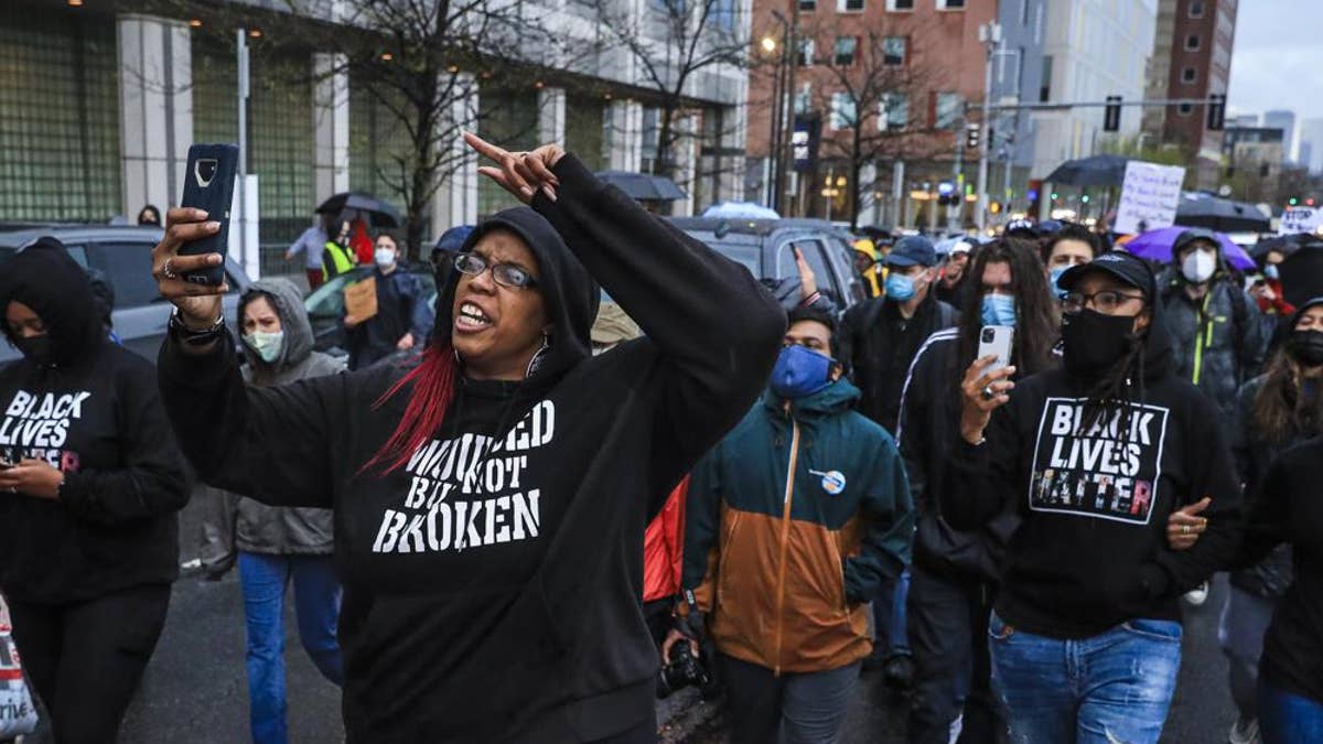 Monica Cannon-Grant, front left, leads demonstrators as they march from Nubian Square to Boston Police headquarters, April 21, 2021, in Boston, as they celebrate the conviction of former Minneapolis police officer Derek Chauvin and demand for an end to police brutality. Federal prosecutors said in a statement Tuesday, March 15, 2022, that Cannon-Grant and her husband, Clark Grant, of Taunton, Massachusetts, have been charged in an 18-count indictment with wire fraud, conspiracy, and making false statements to a mortgage lending business. 
