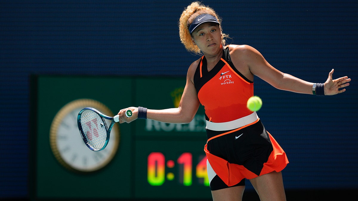 Naomi Osaka of Japan returns a ball against Astra Sharma of Australia in their first round women's match at the Miami Open tennis tournament, Wednesday, March 23, 2022, in Miami Gardens, Fla.