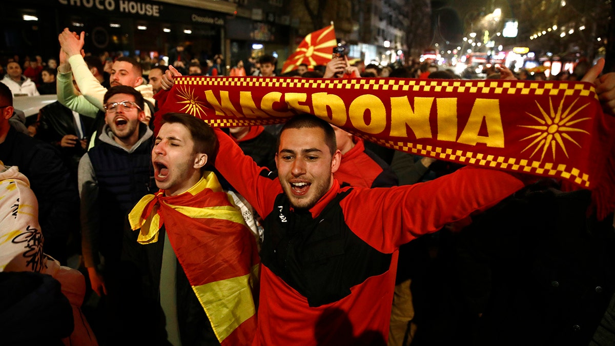 North Macedonia's national soccer team fans celebrate the victory against Italy at the World Cup qualifying play-off soccer match, in a street in Skopje, North Macedonia, late Thursday, March 24, 2022.