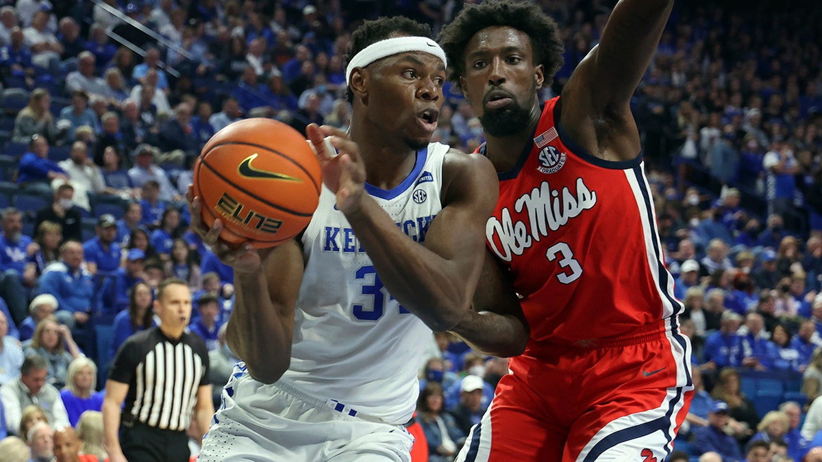 Kentucky's Oscar Tshiebwe, left, is pressured by Mississippi's Nysier Brooks (3) during the first half of an NCAA college basketball game in Lexington, Ky., Tuesday, March 1, 2022.