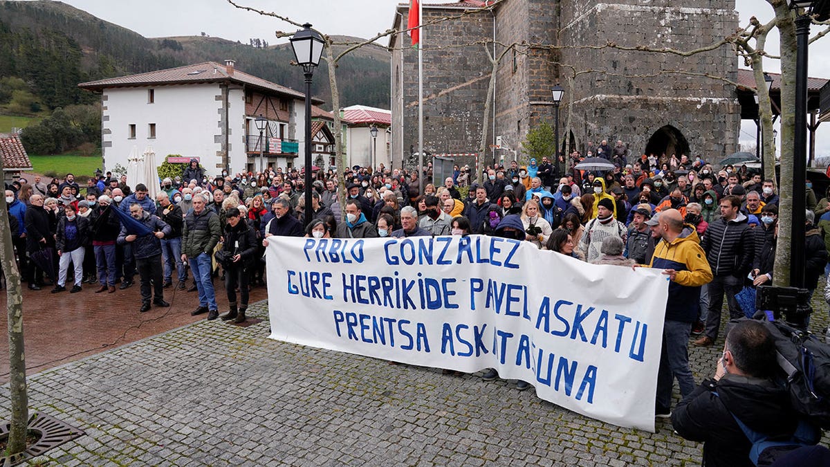 People stand behind a banner reading "Freedom for our neighbor Pablo Gonzalez. Press Freedom", during a demonstration, after Gonzalez was detained by Polish authorities on espionage charges, in Nabarniz, Spain, March 6, 2022. 