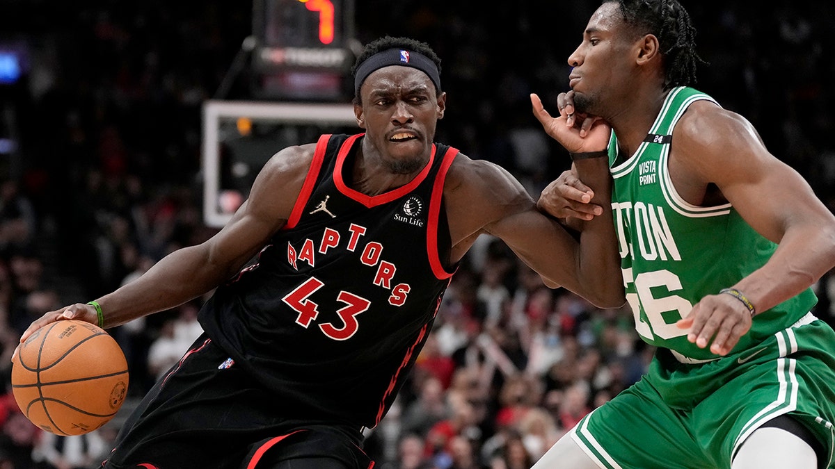 Toronto Raptors forward Pascal Siakam (43) drives past Boston Celtics forward Aaron Nesmith (26) during second-half NBA basketball game action in Toronto, Monday, March 28, 2022.