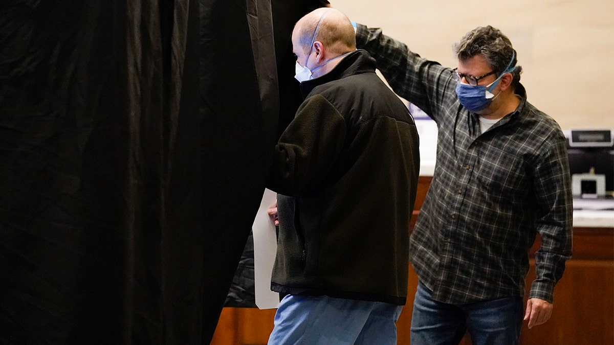 FILE - An election worker helps a voter into a booth at a polling place located at the Museum of the American Revolution in Philadelphia, Tuesday, Nov. 2, 2021. (AP Photo/Matt Rourke, File)