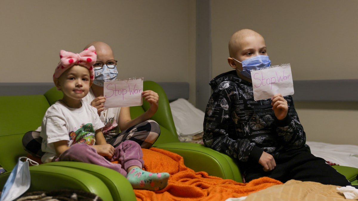 Children patients whose treatments are underway hold papers with the words "no war" written in them, at the hallways of the basement floor of Okhmadet Children's Hospital, as Russia's invasion of Ukraine continues, in Kyiv, Ukraine February 28, 2022. REUTERS/Umit Bektas