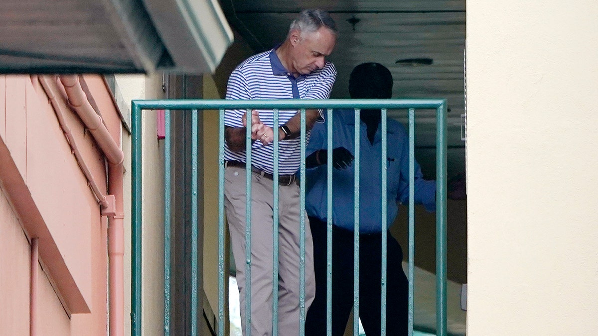 Major League Baseball Commissioner Rob Manfred practices his golf swing as negotiations continue with the players' association toward a labor deal, Tuesday, March 1, 2022, at Roger Dean Stadium in Jupiter, Florida.