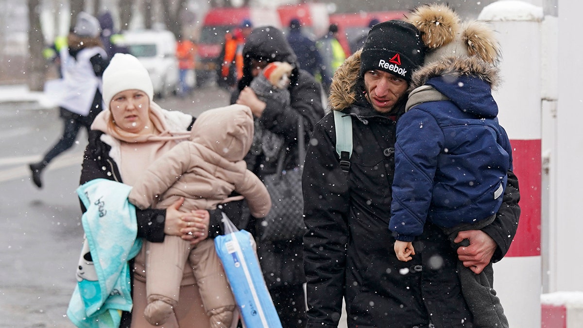 People cross the Ukrainian border to Siret, Romania, Wednesday, March 2, 2022, as they evacuate Ukraine amid Russia´s invasion.