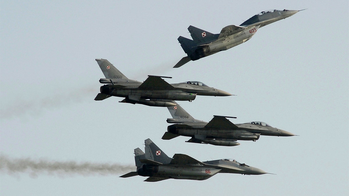 Two Polish Air Force Russian made Mig 29's fly above and below two Polish Air Force U.S. made F-16's fighter jets during the Air Show in Radom, Poland, on Aug. 27, 2011. (AP Photo/Alik Keplicz, File)