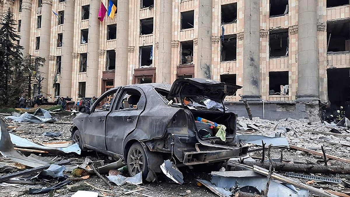 In this handout photo released by Ukrainian Emergency Service, a burnt car is seen in front of a damaged City Hall building, in Kharkiv, Ukraine, Tuesday, March 1, 2022.