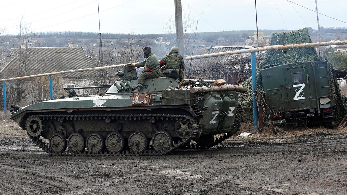 Service members of pro-Russian troops in uniforms without insignia drive an armored vehicle with the symbol "Z" painted on its side in the separatist-controlled village of Bugas during the Ukraine-Russia conflict in the Donetsk region, Ukraine, March 6, 2022. 