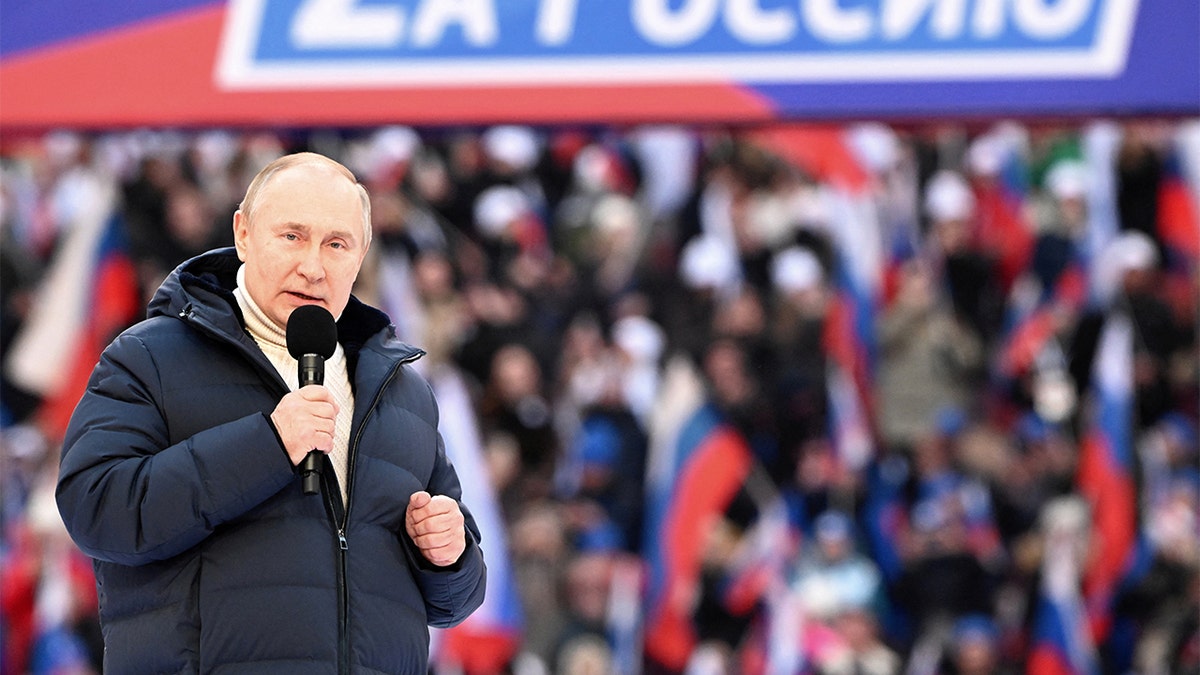 Russian President Vladimir Putin delivers a speech during a concert marking the eighth anniversary of Russia's annexation of Crimea at Luzhniki Stadium in Moscow, March 18, 2022. The banner reads: "For Russia." Sputnik/Sergey Guneev/Kremlin via REUTERS