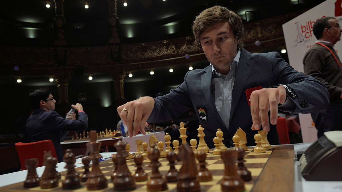 Russian grandmaster Sergey Karjakin adjusts his pieces before a game against Norwegian world chess champion Magnus Carlsen at the IX Chess Masters Final in Bilbao, northern Spain, July 21, 2016.