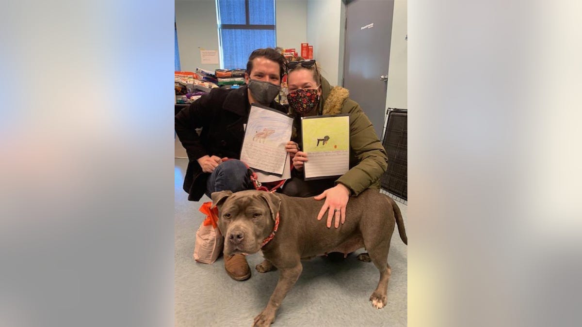 A family in Richmond, Virginia, are seen after the adoption of a dog at Richmond Animal Care &amp; Control. Local students had written stories and created illustrations that were later pinned to kennels to motivate potential adopters to bring an animal home.