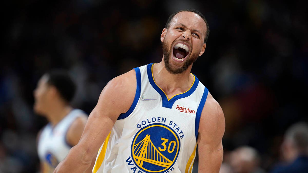 Golden State Warriors guard Stephen Curry reacts after Jordan Poole hit a 3-point basket late in the second half of the team's NBA basketball game against the Denver Nuggets on Thursday, March 10, 2022, in Denver.